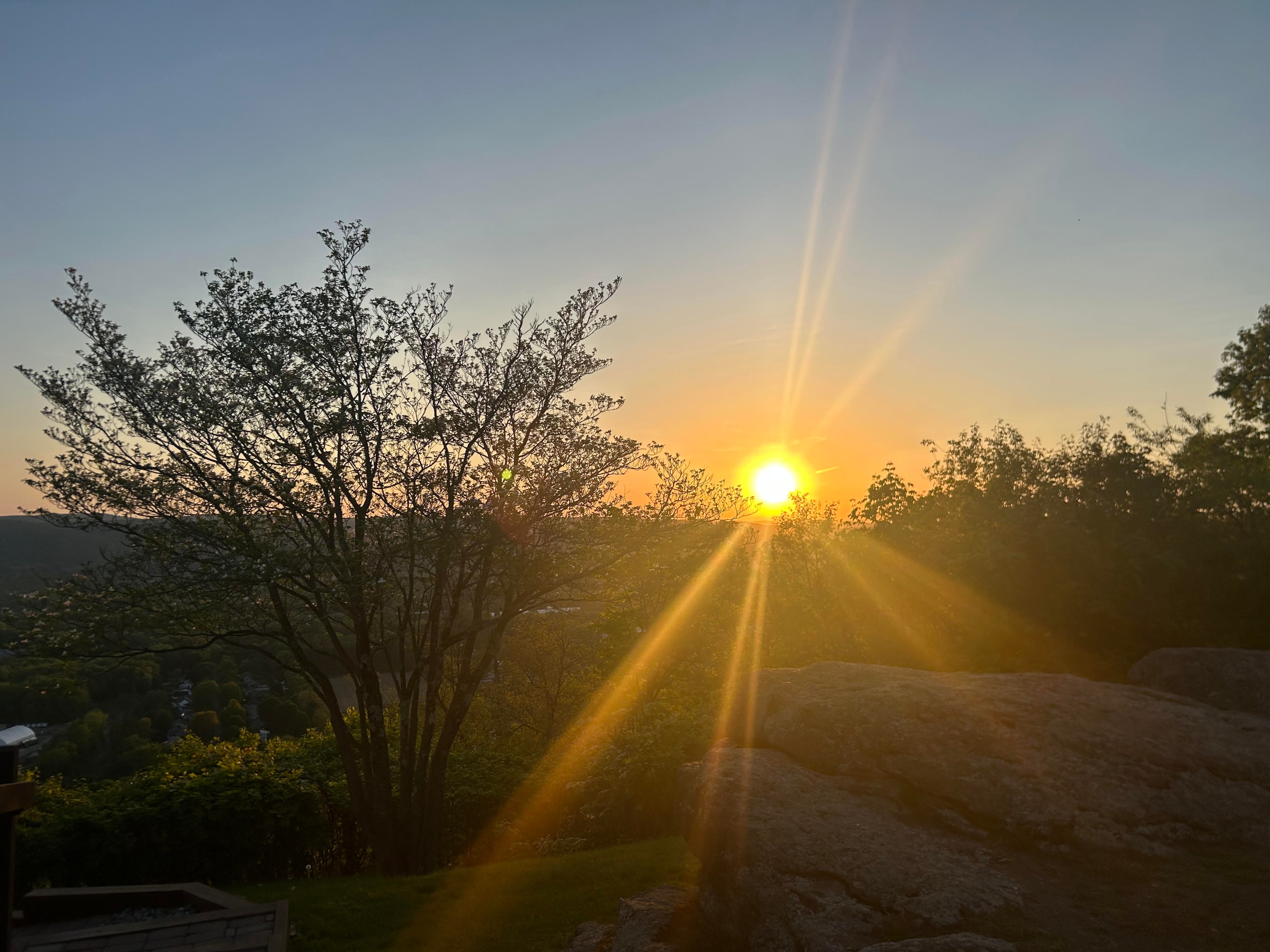 Sunset over the valley from Mount Sugarloaf, sun rays through the trees